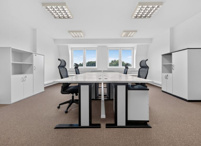 Spacious offices with desks, black chairs, and storage cabinets, floor with wood decor.