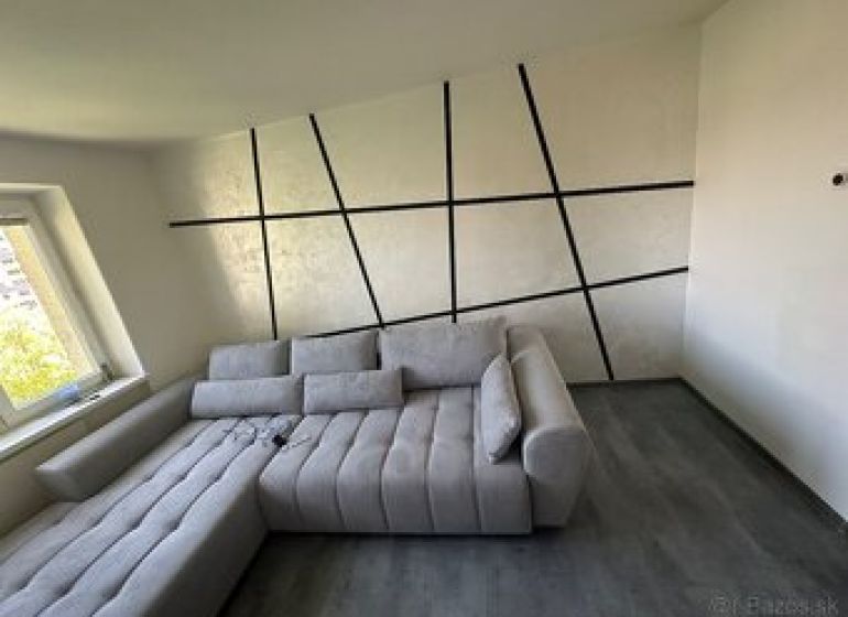 Interior of a 2-room apartment with a comfortable sofa and a floor with a wooden decor.