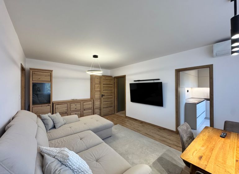Living room in a 3-room apartment with a wooden decor floor and modern furniture.