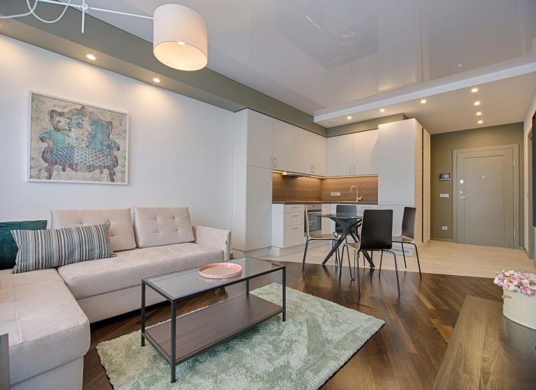 Living room in a 3-room apartment with a wooden decor floor and stylish furniture.