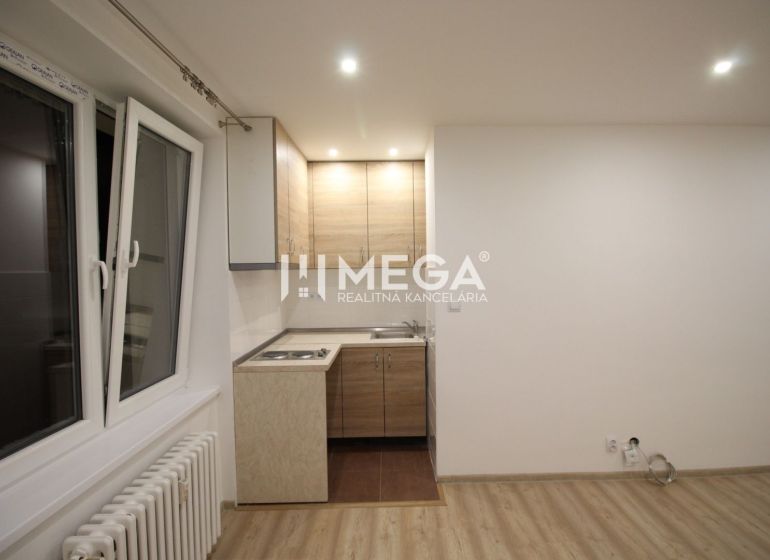 A kitchen in a holiday apartment with a kitchen unit and a wooden decor floor.