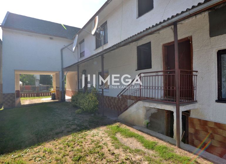 A family house in Hažín nad Cirochou with a green yard and metal stairs.