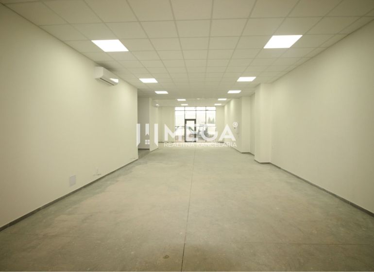 Interior of a commercial space with white walls and textured flooring without decor.