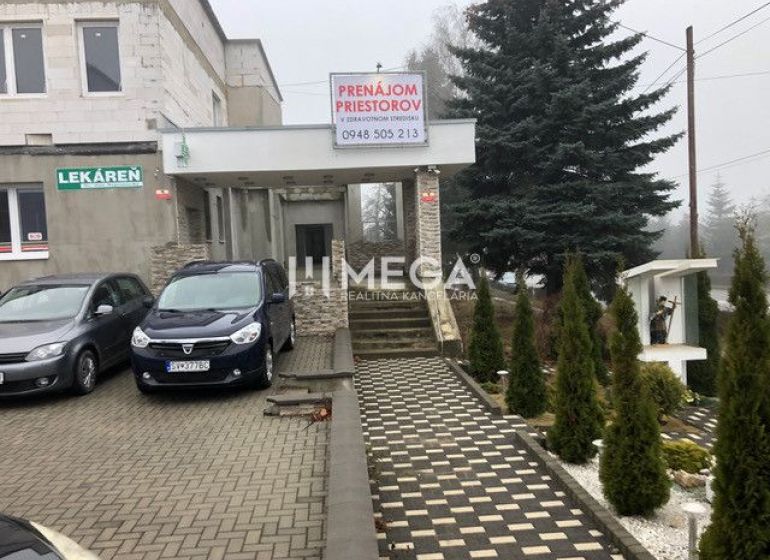 A building on SNP Street in Snina with a parking lot and an advertisement for space rental.