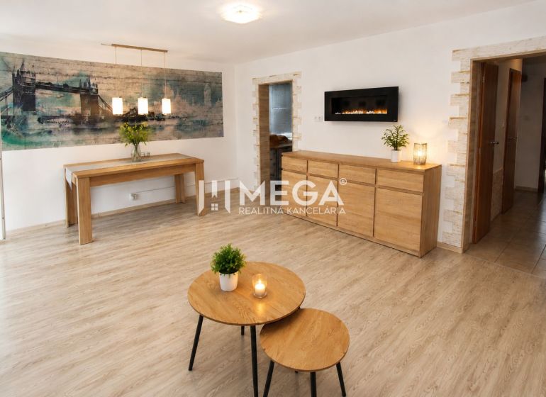 A stylish living room in a three-room apartment with a wooden decor floor.