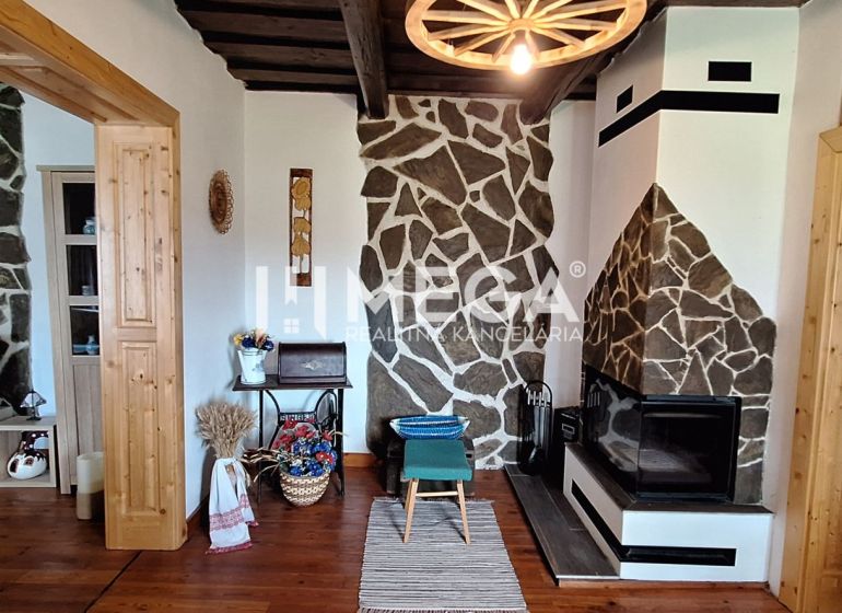 Interior of a family house with a fireplace, stone walls, and a floor with a wooden decor.