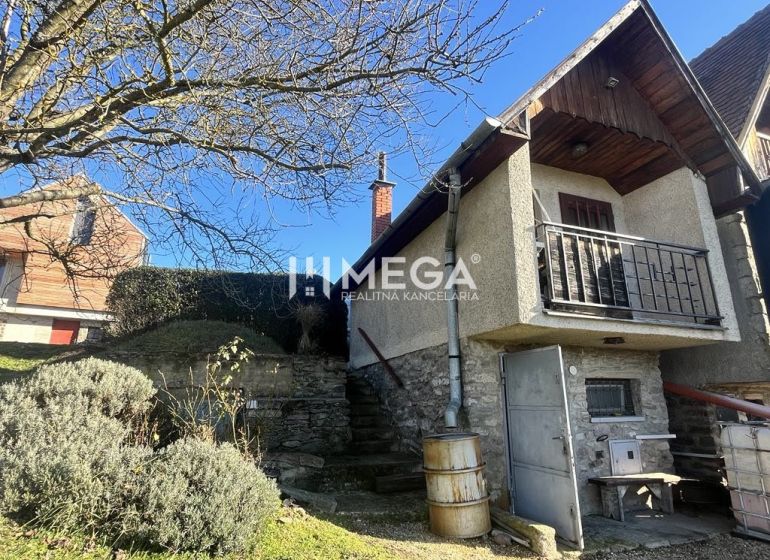 A family house in the village of Viničky on Viničky Street with stone stairs and a balcony.