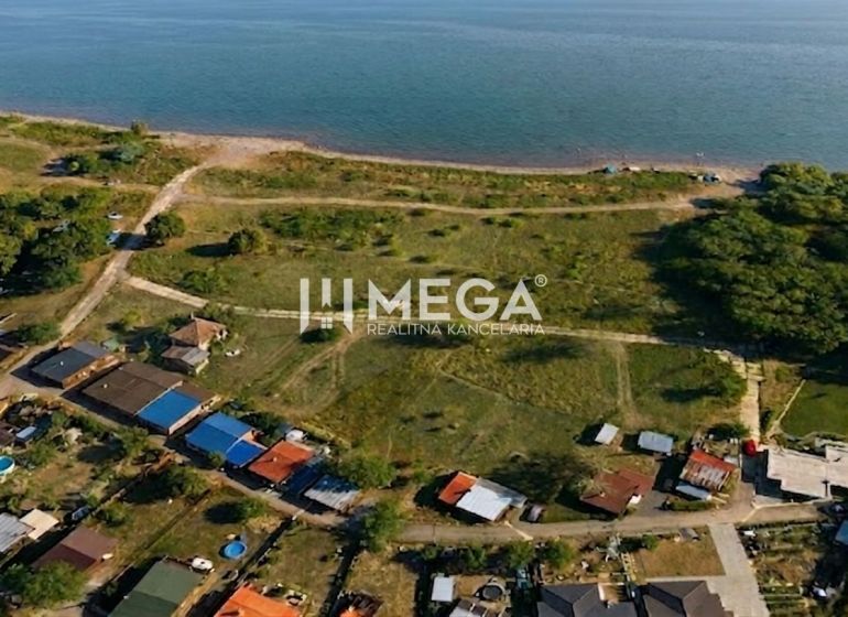 Aerial view of residential plots near a water body in the village of Vinné.
