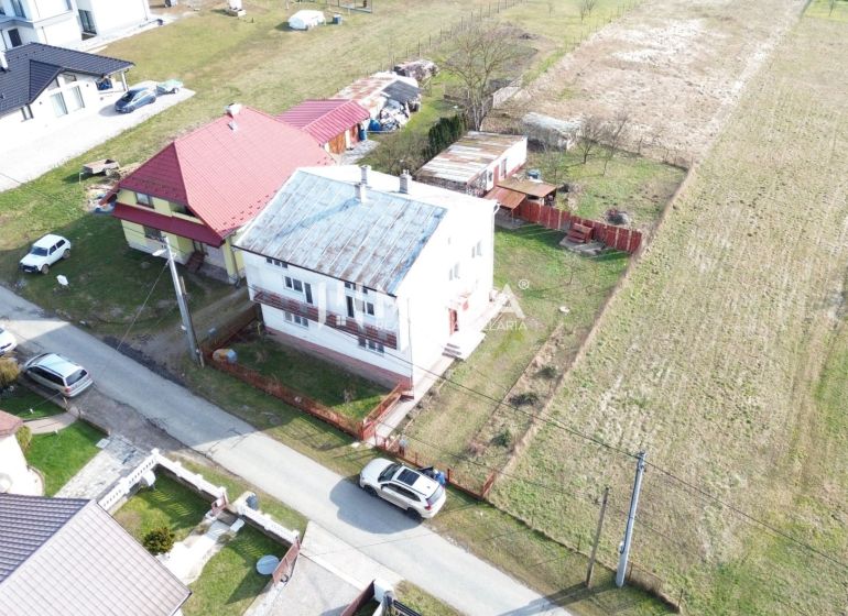 Aerial view of family houses in the village of Myslina, Myslina Street, with surrounding fields.