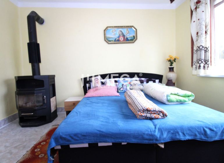Interior of a family house with a bed, stove, and colorful accessories.