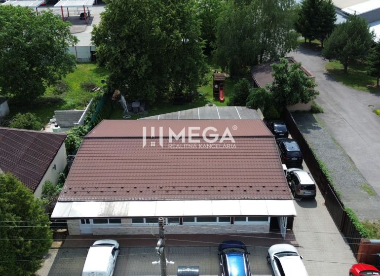 Gastro premises on Budovateľská Street in Vranov nad Topľou surrounded by cars and greenery.