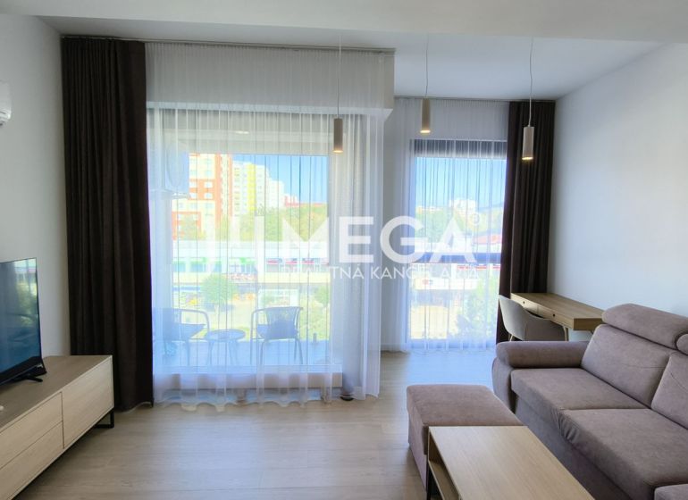 A living room in a three-room apartment with a comfortable sofa and large windows.