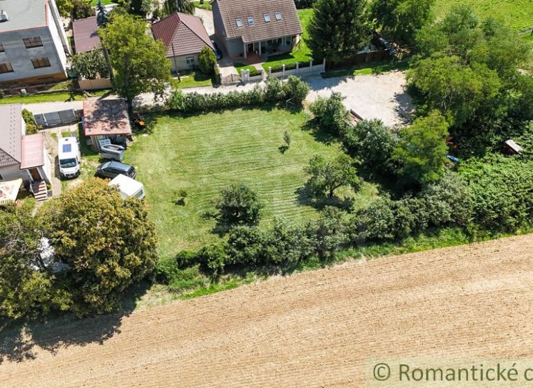 Houses with gardens in Pastuchov surrounded by fields and greenery.