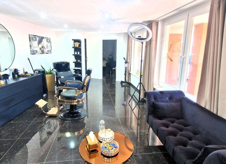 Commercial space with black furniture, an armchair, and decorative elements, floor with a dark decor.