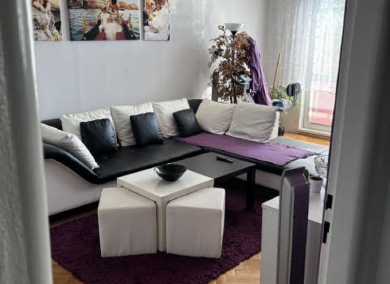 A comfortable living room with a wooden decor floor in a sought-after 2-room apartment.