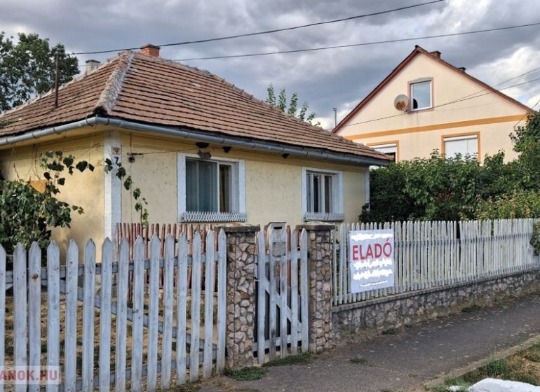 A family house in Tornyosnémeti with a brick roof and a colorful fence.