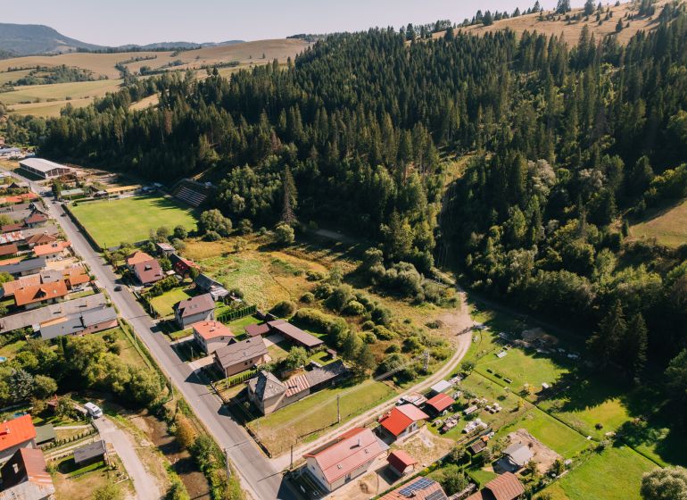 Aerial view of residential plots in Čierny Balog on Švermova Street surrounded by forests.