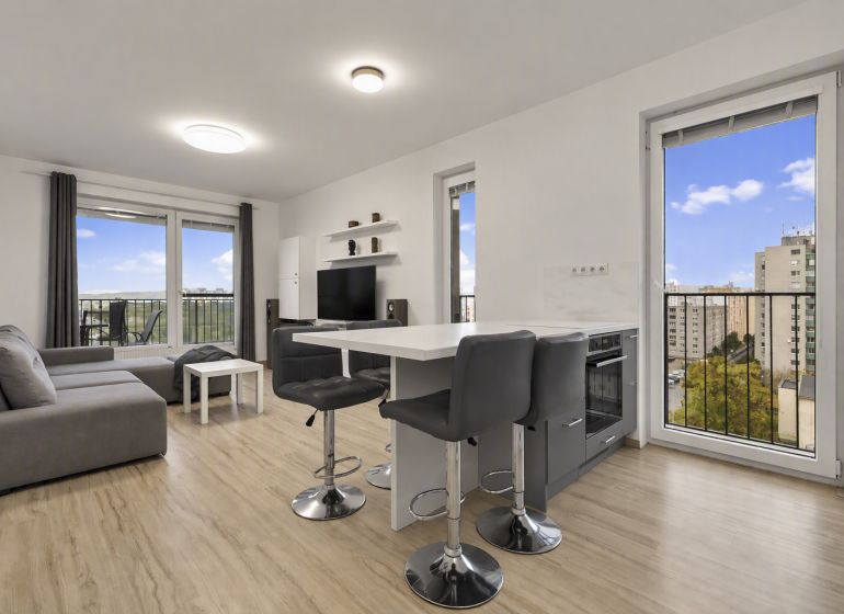 Living room with a kitchenette and a wooden decor floor in a 2-room apartment.