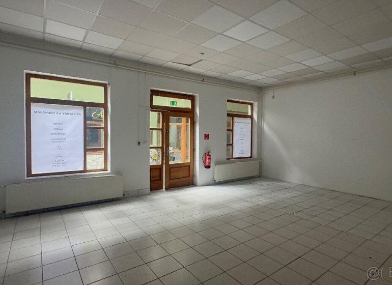 Commercial spaces with tiles and large windows, waiting to be utilized.