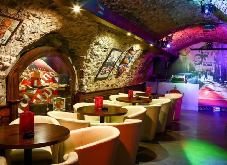 A bar in historical gastro premises with stone walls and a wooden decor floor.