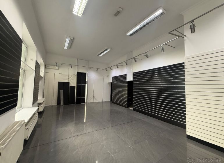Commercial premises with dark walls and gray tiles, available for rent.