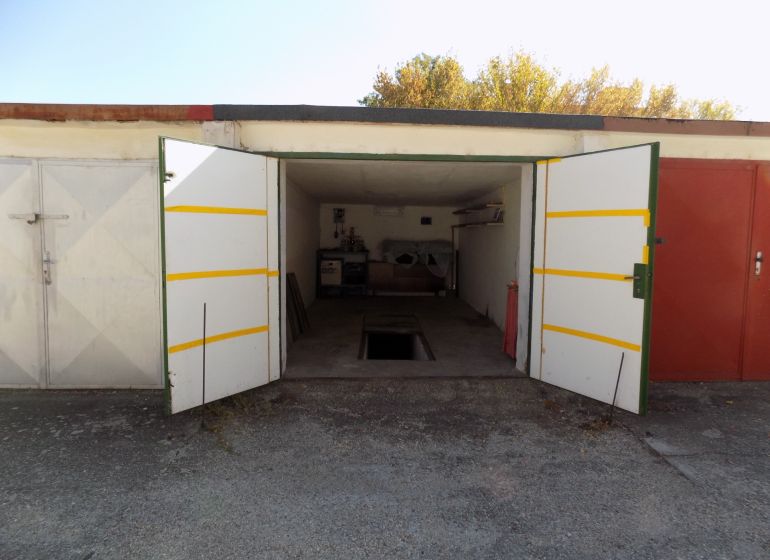 An open garage on Petőfi Row in Štúrovo with a pit and stored items.
