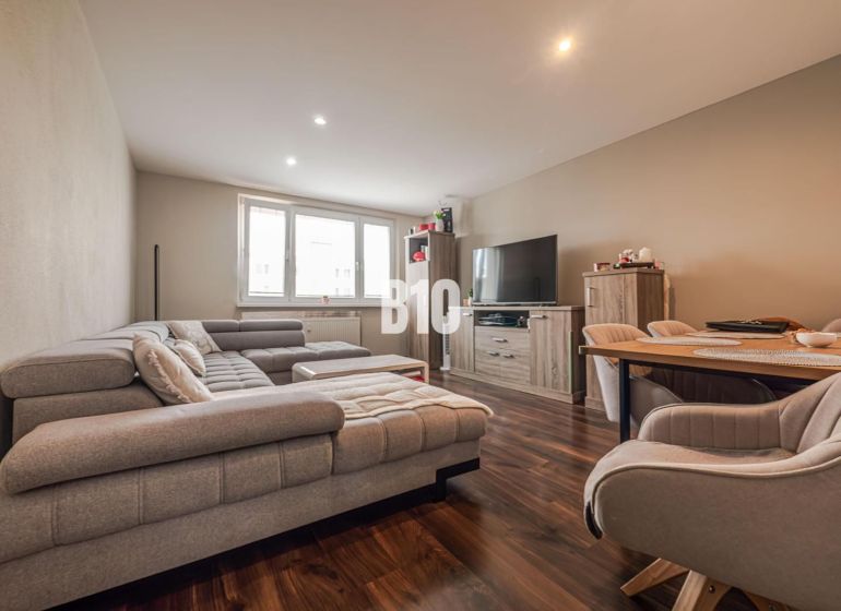 Living room in a 3-room apartment with a comfortable sofa and a wooden decor floor.