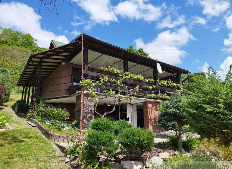 A cottage in Modrý Kameň with a terrace and a well-maintained garden under a blue sky.