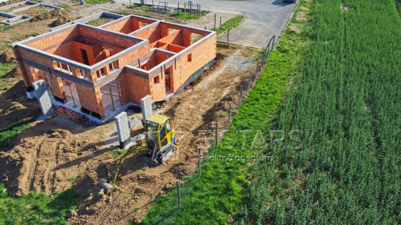 Construction of a family house in Trenčín with a brick wall and building equipment.