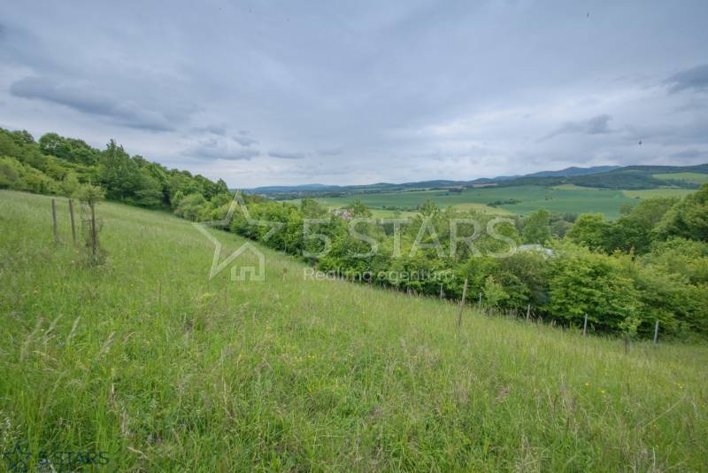 A meadow surrounded by forest and hills on the Recreational grounds in Kostolná-Záriečie.