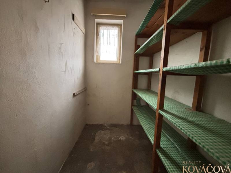 A small room with a bright window and wooden shelves in a 4-room apartment.