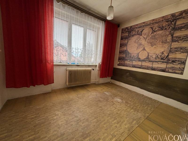 A room with an antique map on the wall and red curtains in a 4-room apartment.