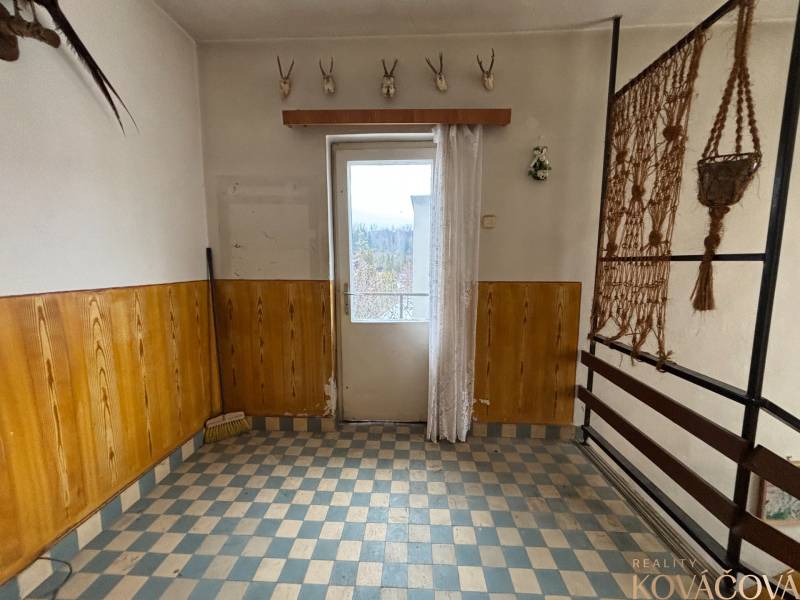 Interior of a 4-room apartment with ceramic flooring, wooden paneling, and hunting trophies.