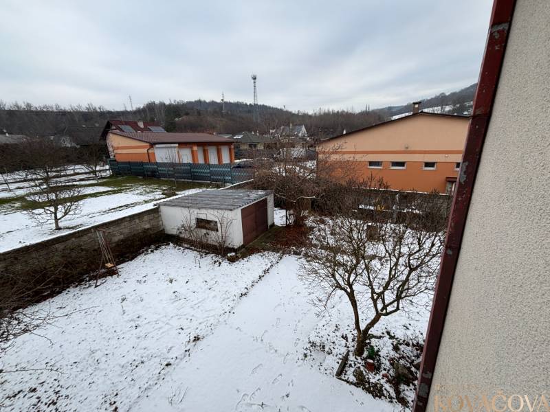 A snowy garden with trees and an annex in Zamarovce, Trenčín, behind a 4-room apartment.