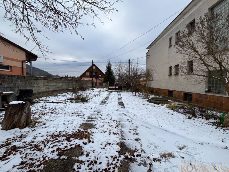 A snowy garden in Zamarovce, Trenčín, next to a 4-room apartment with a walkway.