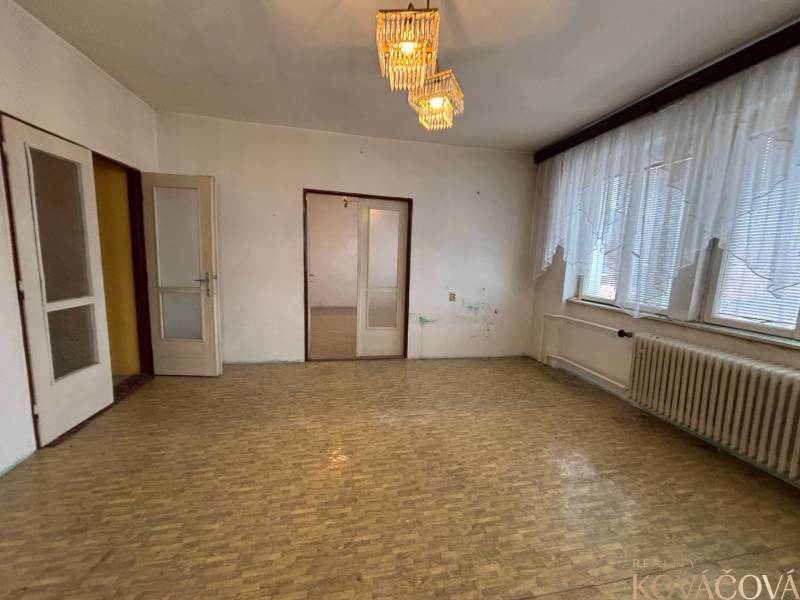 A room in a 4-room apartment with a parquet floor and a large window with a radiator.
