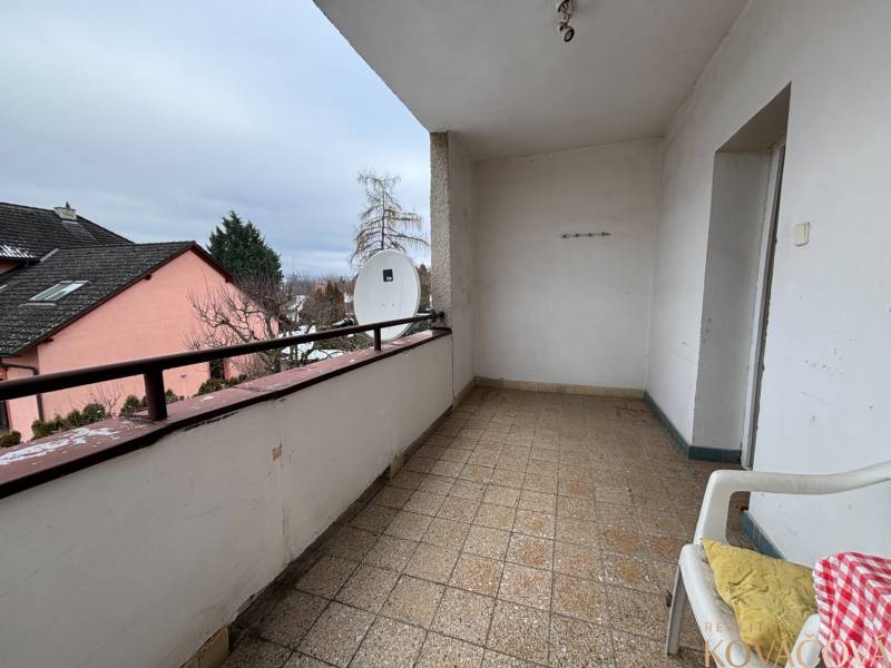 A balcony in a 4-room apartment with a satellite dish and a chair on the terrace.