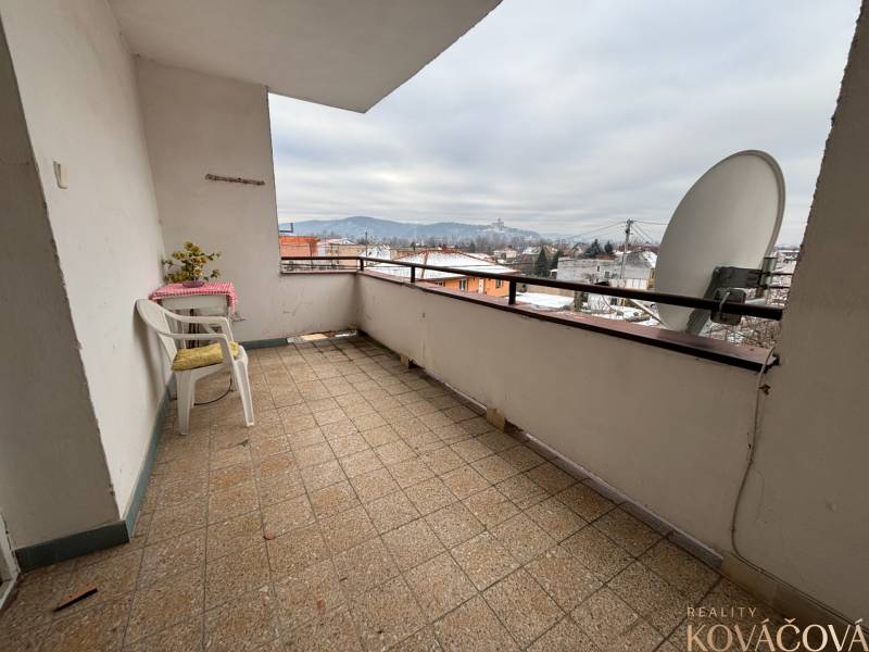 The balcony of a 4-room apartment in Zamarovce, Trenčín. A view of the snow-covered city and hills.