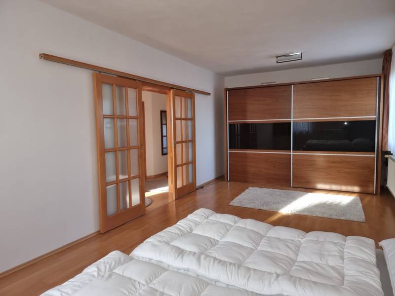 A bedroom in a family house with sliding doors and a large wardrobe.
