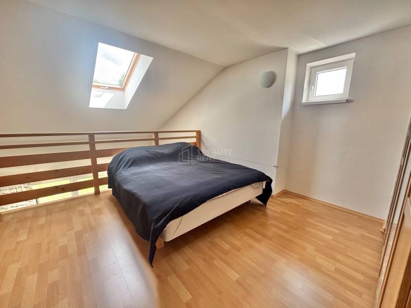 Bedroom in a 2-room apartment with a bed and a skylight, pleasantly illuminated.