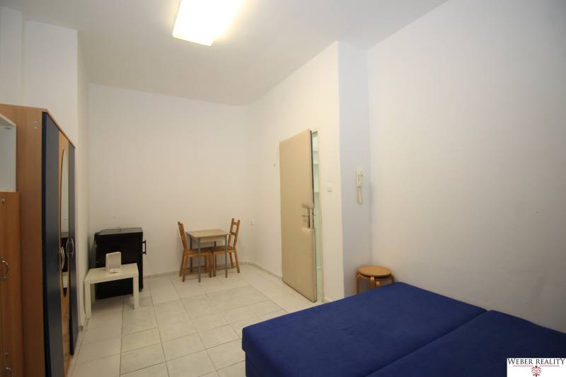 Simple furnishing of a studio apartment with a sofa, table, and chairs.