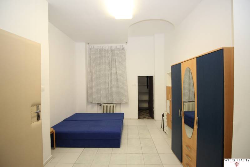 Bright 1-room apartment with a blue bed, wardrobe, and white tiles.