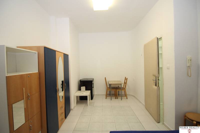 In the 1-room apartment, there is a wardrobe, a table with chairs, and a table on a small table.
