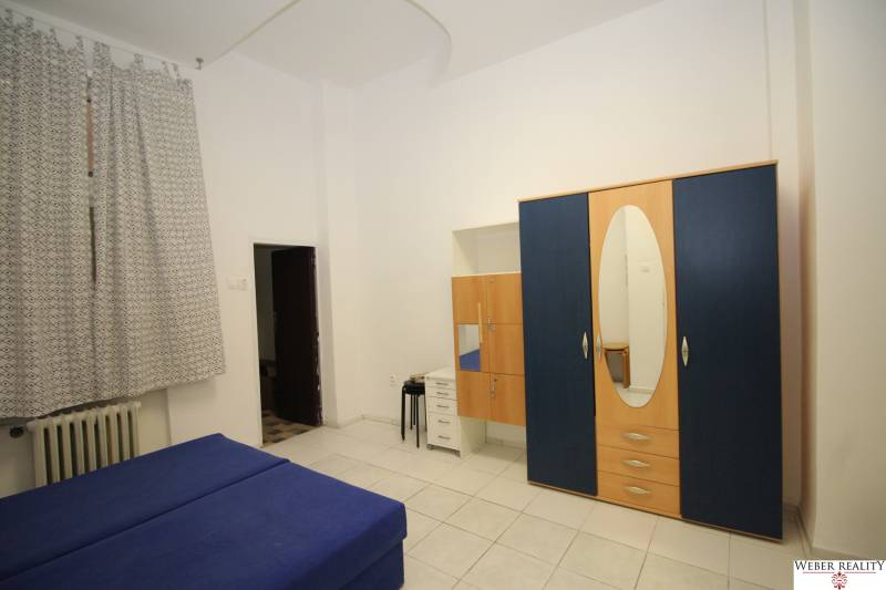 1-bedroom apartment with blue furniture, a wardrobe, and curtains.
