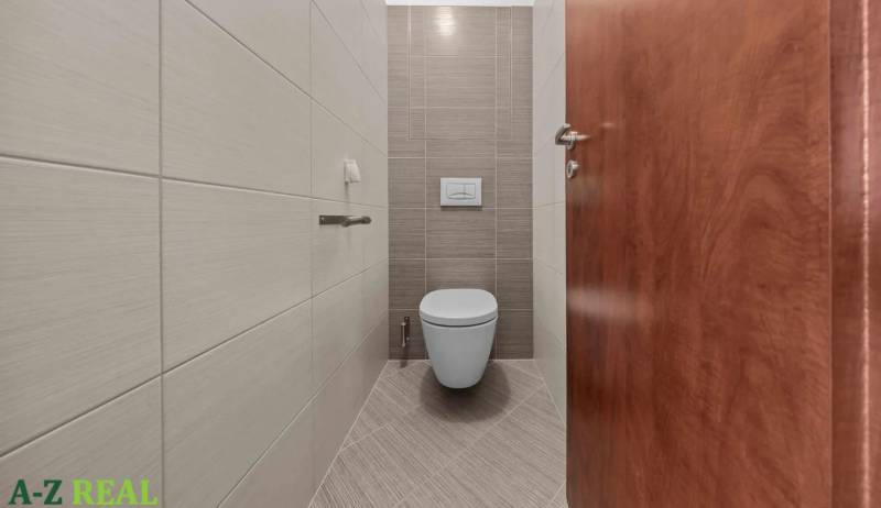 A bathroom with tiled walls in a 2-room apartment.