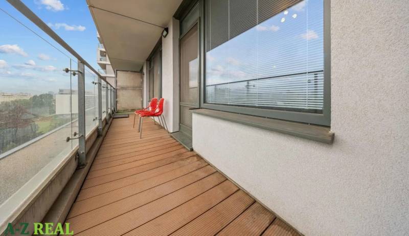 A balcony with two red chairs at a 2-room apartment on Nevädzova Street, Bratislava - Ružinov.