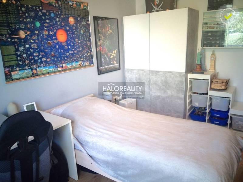 One of the rooms in a 3-room apartment contains a bed, a wardrobe, and decorative posters.