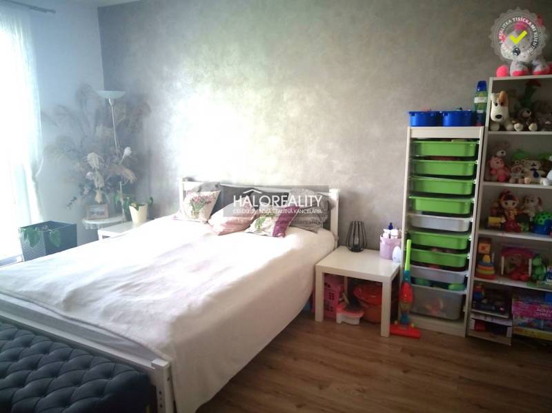 Bright bedroom in a 3-room apartment with a bed, storage space, and children's toys.