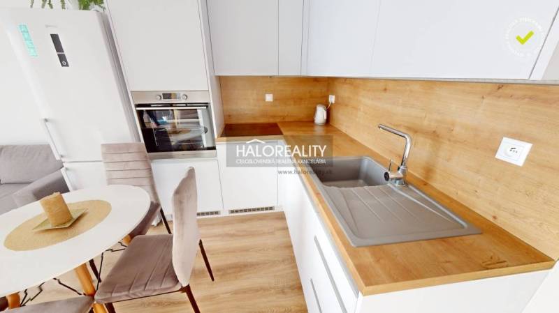 A kitchen with a wooden countertop and dining table in a 2-room apartment.