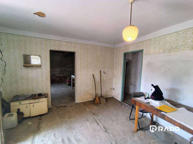 A room in a family house with worn-out furniture and cracked walls.